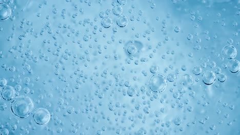 oxygen bubbles in water on a blue abstract background on super slow motion.