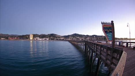 Von-Nacht-Zu-Tag-Zeitraffer-Der-Lichter-Der-Stadt,-Die-Vom-Ventura-Pier-In-Ventura-Kalifornien-Vom-Ozean-Reflektiert-Werden