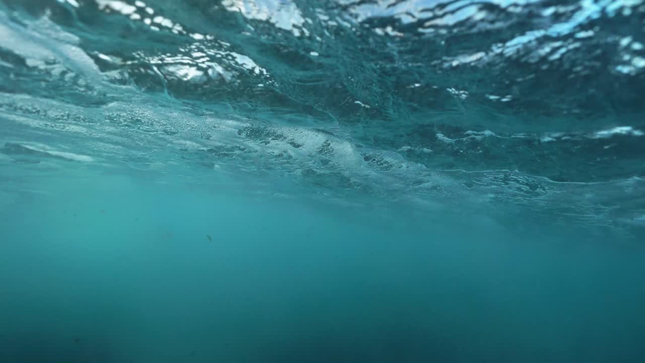 pov bajo el agua de una ola en la superficie en aguas turquesas