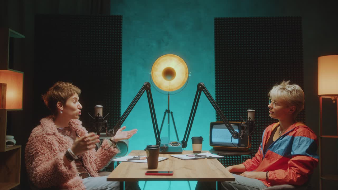 Young Female Blogger Having Discussion with Podcast Host in Recording Studio