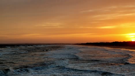 el esplendor del atardecer: el horizonte ardiente sobre las suaves olas del océano, una obra maestra de calor y movimiento