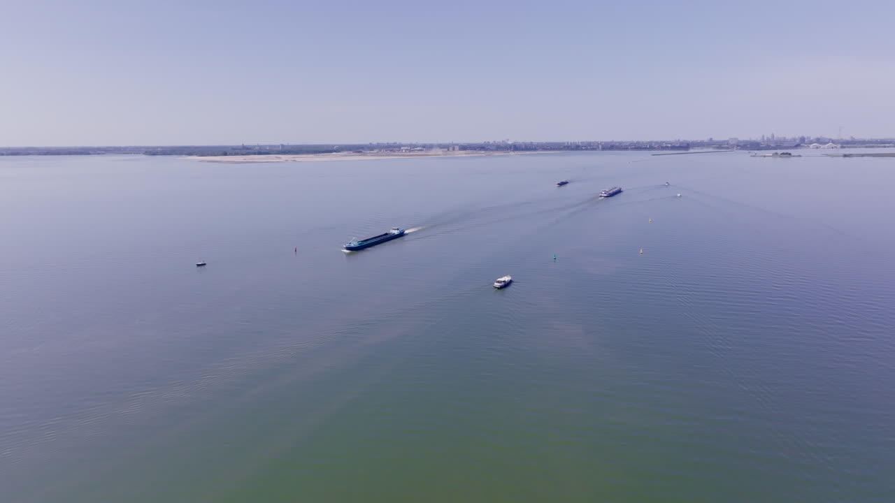 Scenic aerial shot capturing a Luxemotor vessel cruising along still waters in The Netherlands, highlighting Dutch maritime heritage and the tranquil beauty of Flevoland