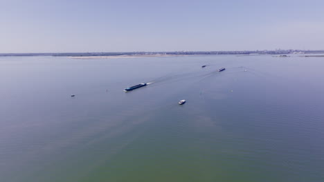 scenic aerial shot capturing a luxemotor vessel cruising along still waters in the netherlands, highlighting dutch maritime heritage and the tranquil beauty of flevoland