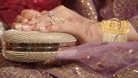 woman's hands holding a decorated clutch at a wedding ceremony