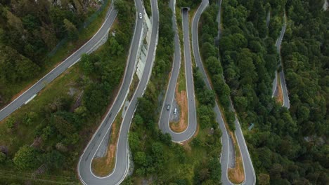 flying above the scenic mountain serpentine road plöckenpass in italy by the natural austrian alps in summer with green forest trees and cars on the street