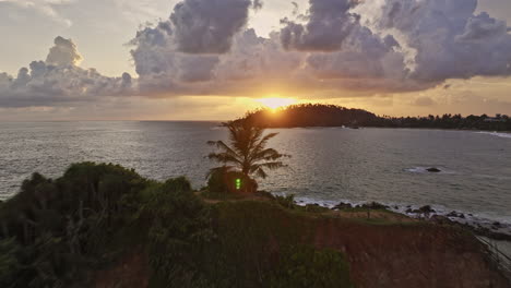 Mirissa-Sri-Lanka-Aerial-v14-cinematic-drone-flyover-Parrot-Rock-capturing-exotic-tropical-beach-and-beautiful-Indian-ocean-with-golden-sun-setting-on-the-horizon---Shot-with-Mavic-3-Cine---April-2023