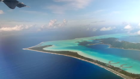 view out of the aircraft window on the lagoon of bora bora, french polynesia