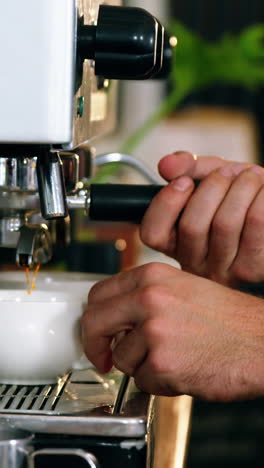 camarero haciendo una taza de café