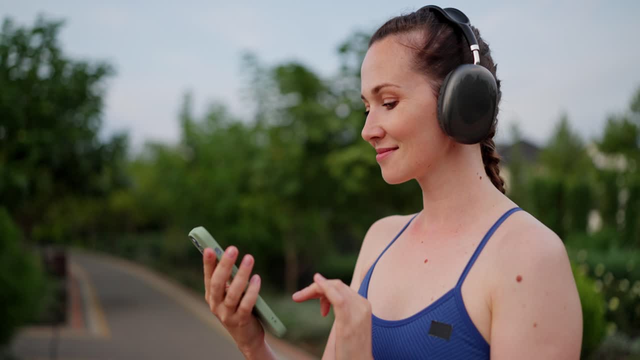 mujer haciendo ejercicio al aire libre con auriculares y teléfono