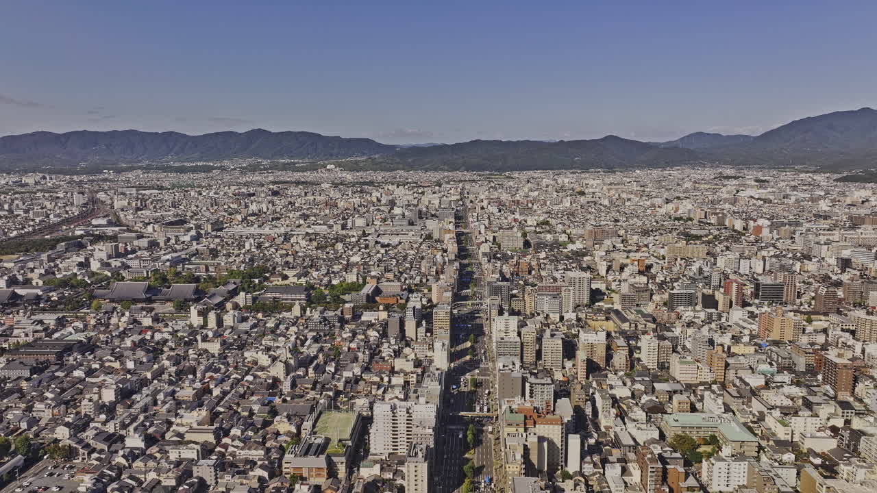 Kyoto Japan Aerial v43 tracking flyover Shimogyo Ward capturing a high-density cityscape with modern buildings, historic temples, and distant mountains - Shot with Mavic 3 Pro Cine - Oct 8th 2023