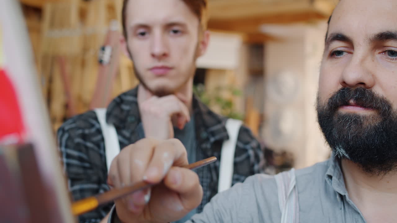 Two artists painting together in a studio