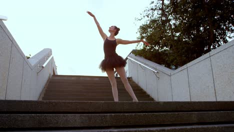 bailarina de ballet estirándose en la escalera 4k