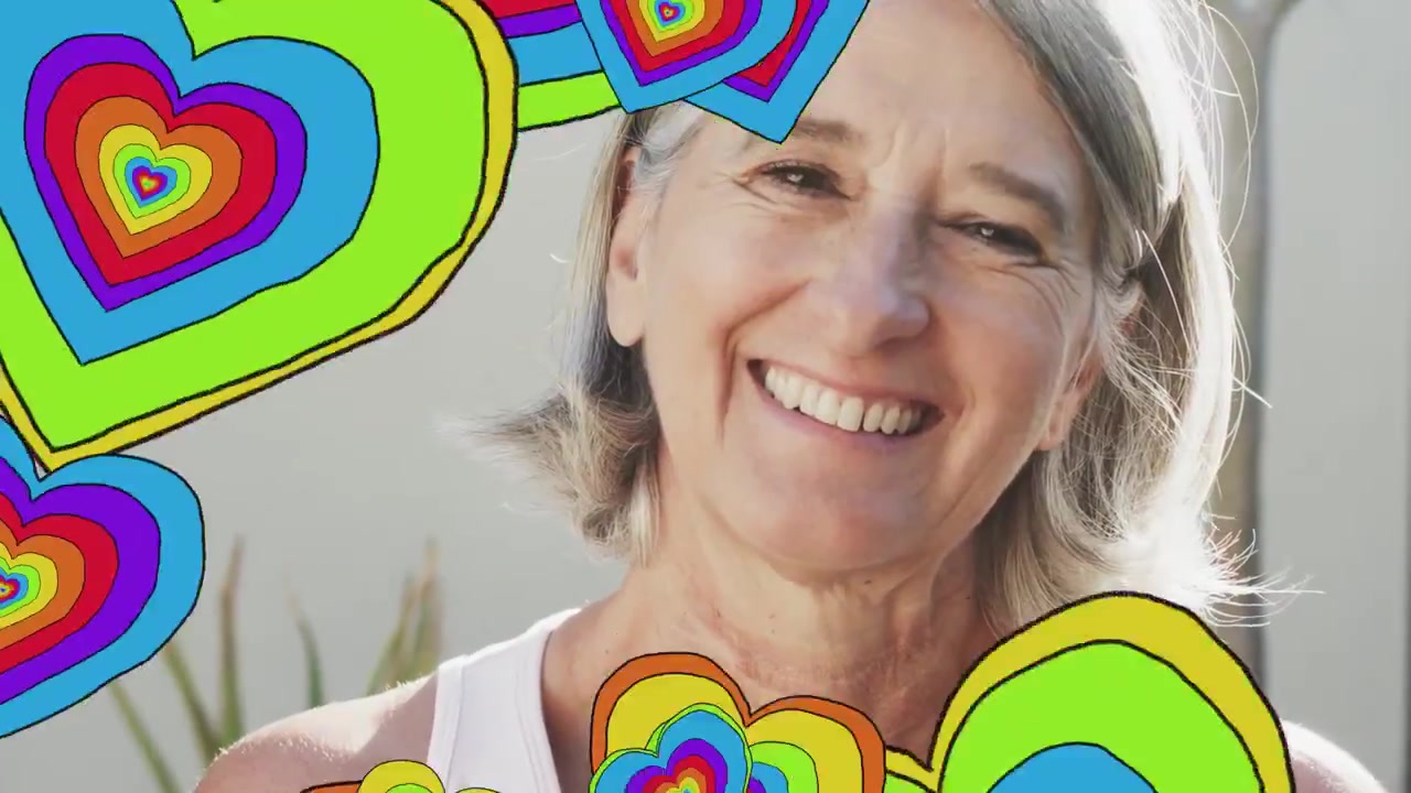 Lachende vrouw zit bij het raam, waarbij bij het afspelen regenboogharten haar gezicht bedekken en vervolgens onthullen voor advertenties.