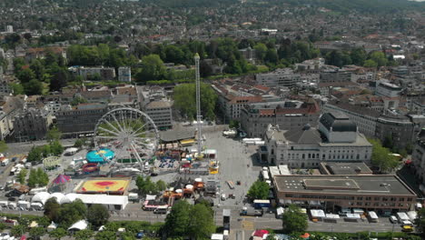 beautiful aerial drone dolly shot flying towards amusement park ferris wheel with the city of zürich, switzerland in the background during zürichfest