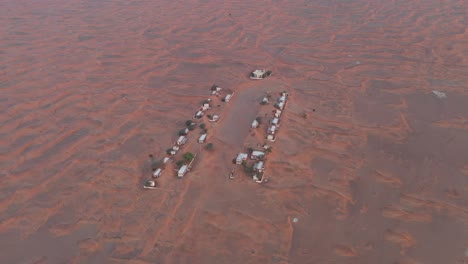 Vista-Aérea-De-Un-Pueblo-Abandonado-Vacío-Y-Casas-Cubiertas-De-Arena-Del-Desierto-Cerca-De-Dubai