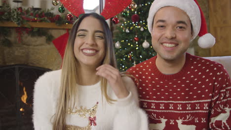 Young-Couple-Waving-and-Talking-to-Camera-During-Christmas-Video-Call-