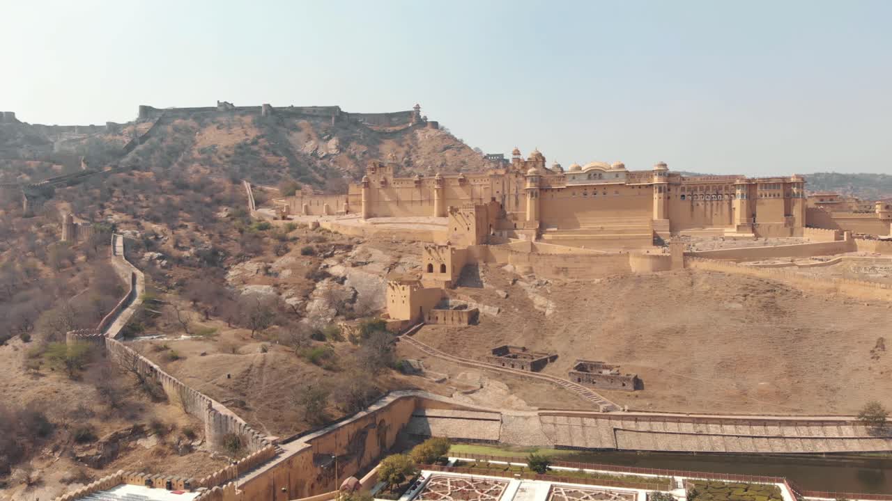 Giardino Kesar Kyari nel lago Maotha dominato dal forte Amber a Jaipur, Rajasthan, India - Ripresa aerea ascendente in sorvolo