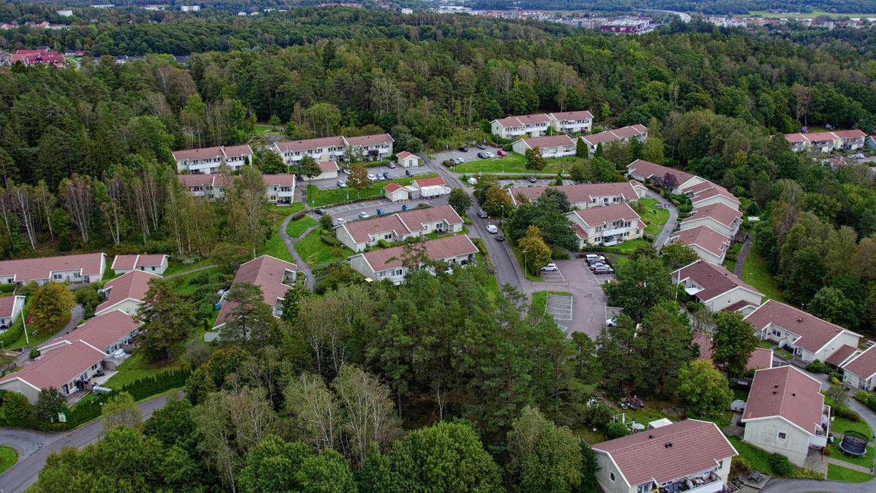 Aerial drone shot of terraced houses neighborhood in Kungalv with residential homes streets green trees and planned community layout in quiet suburban landscape kungälv, sweden