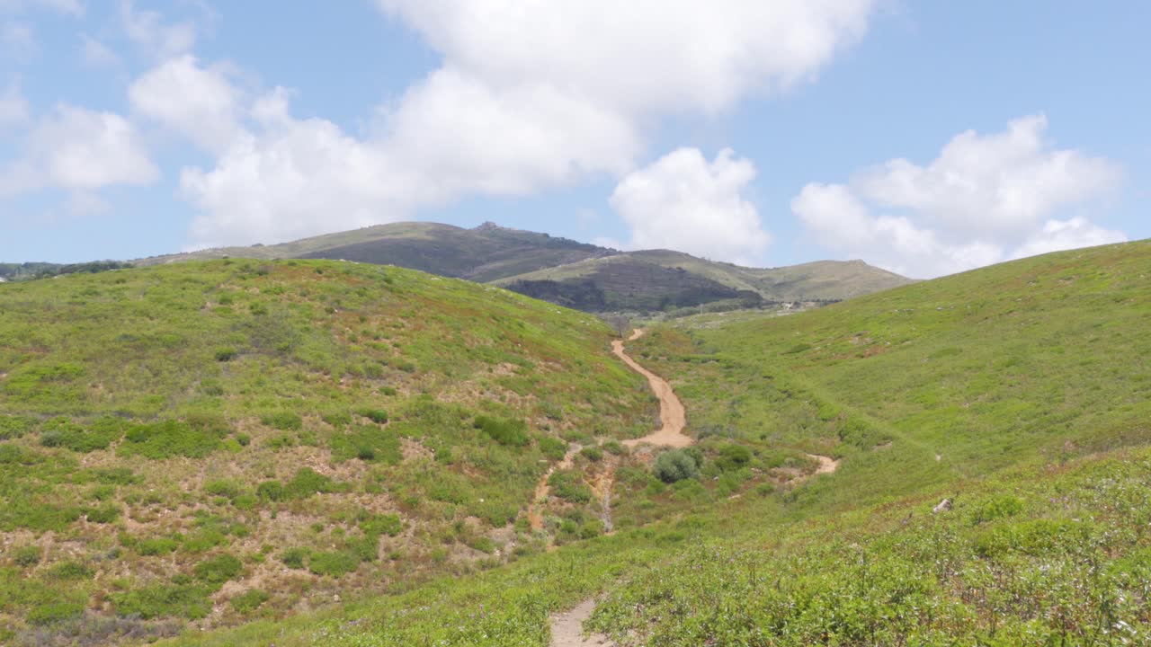 un camino que serpentea a través de un valle montañoso plano en el parque natural de sintra-cascais, portugal