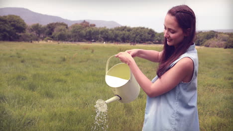 mujer feliz vertiendo agua sobre las flores