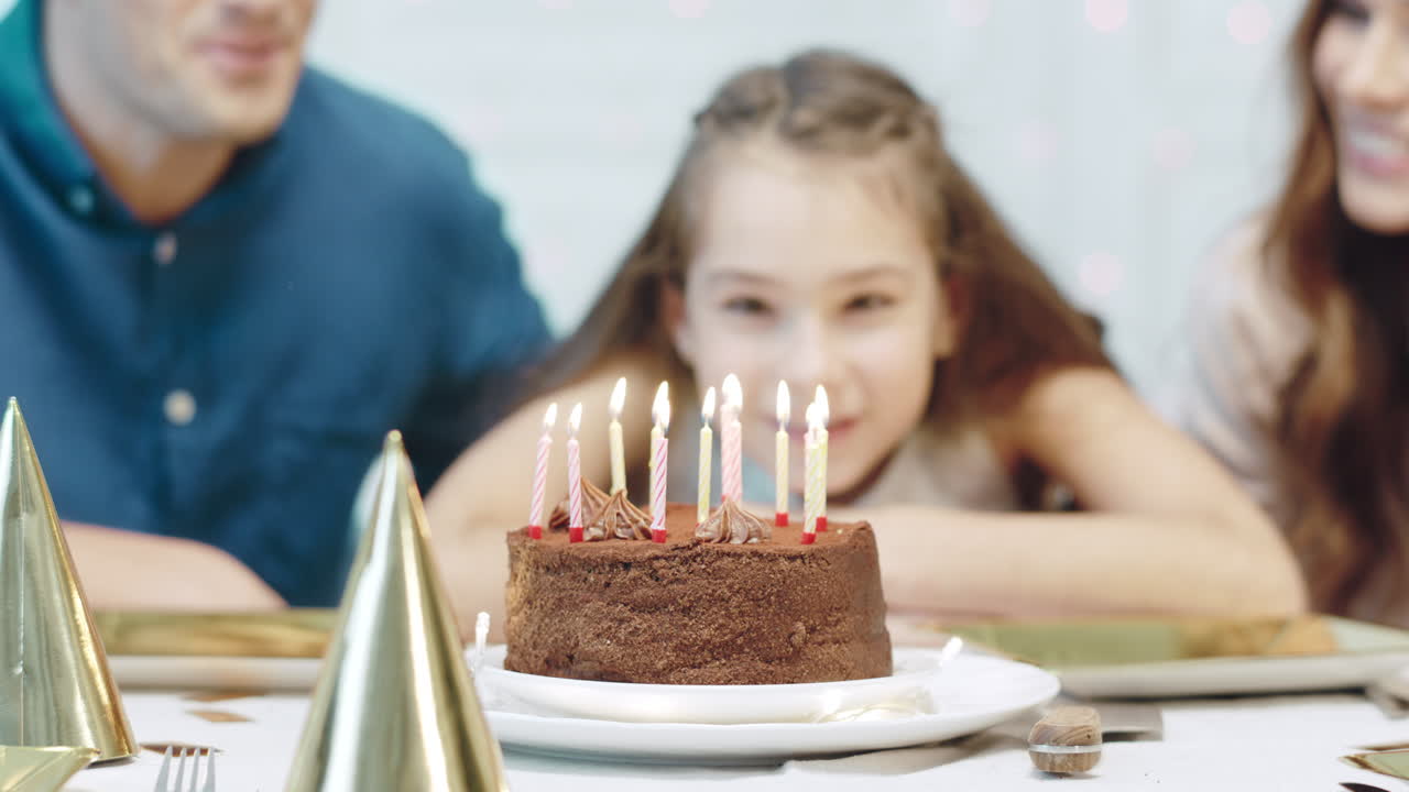 retrato de una chica sonriente soplando velas de cumpleaños en una casa de lujo