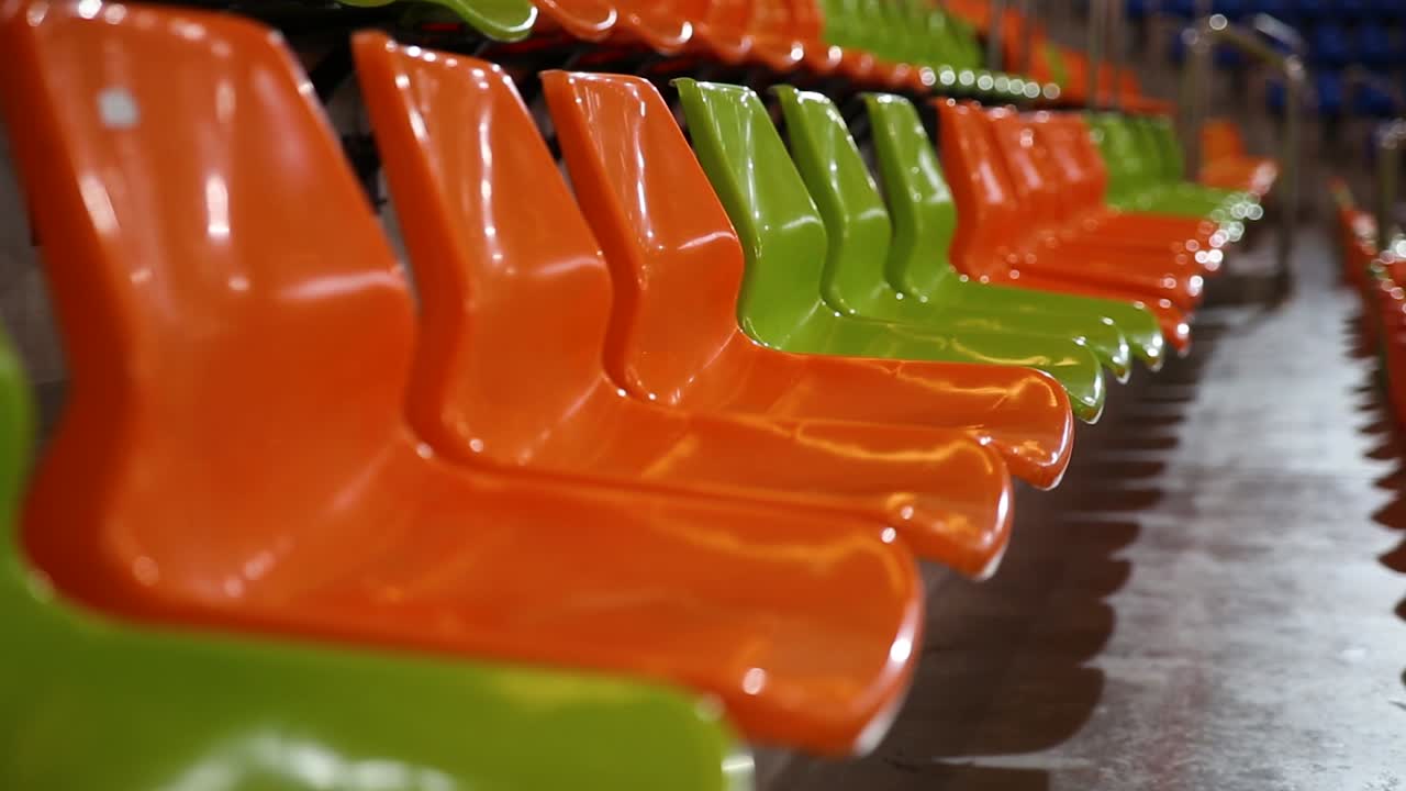 filas de sillas de estadio verdes y naranjas