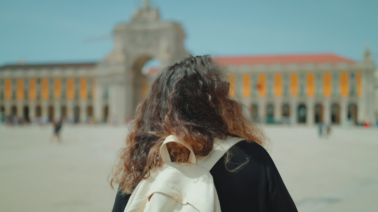 배 을 들고 있는 여자 가 도시 광장 을 바라보고 있다