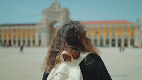 woman with backpack views a city square