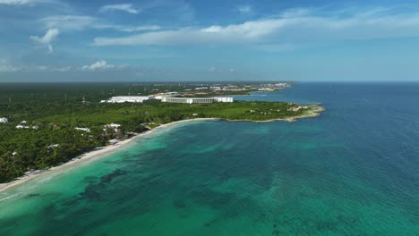 Aerial-view-overlooking-the-sunny-coastline-of-Xpu-Ha,-Mexico---descending,-pull-back,-drone-shot