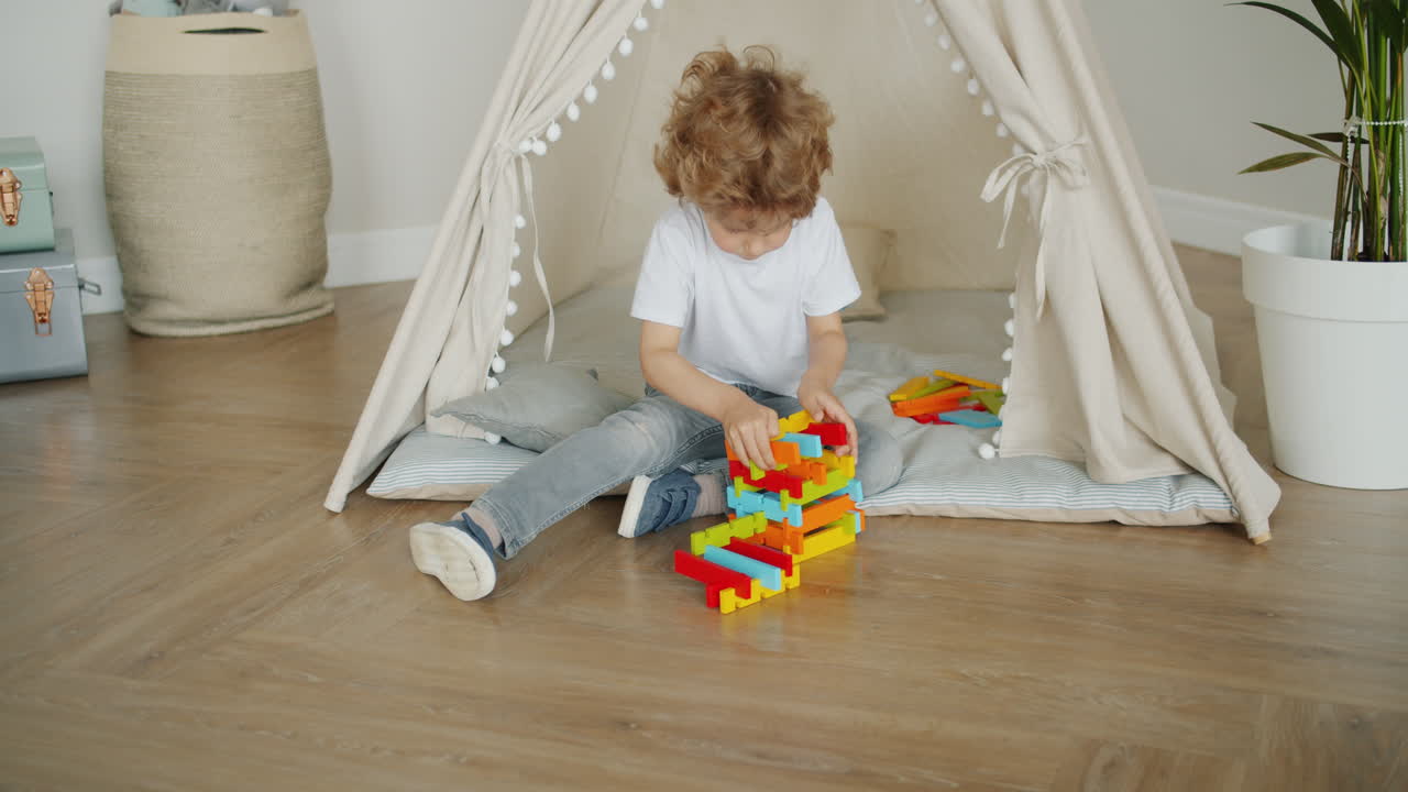 Child Playing with Building Blocks in a Play Tent