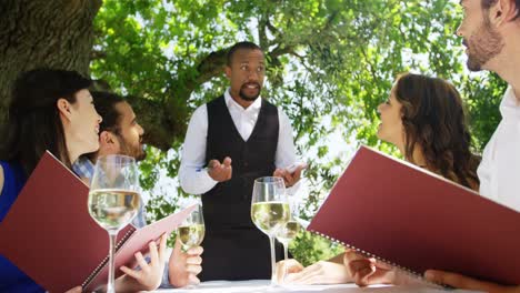 waiter taking an order from couples