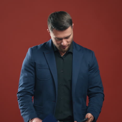smiling man talking on the phone. office worker in dark blue suit with a folder in his hand isolated in studio. portrait of a happy businessman with a mobile phone.