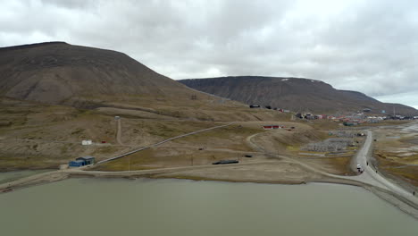 backwards drone flight in svalbard - revealing longyearbyen city on left side