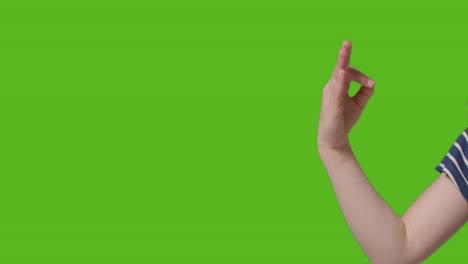 primer plano de una niña haciendo meditación mudra gesto a la cámara contra la pantalla verde