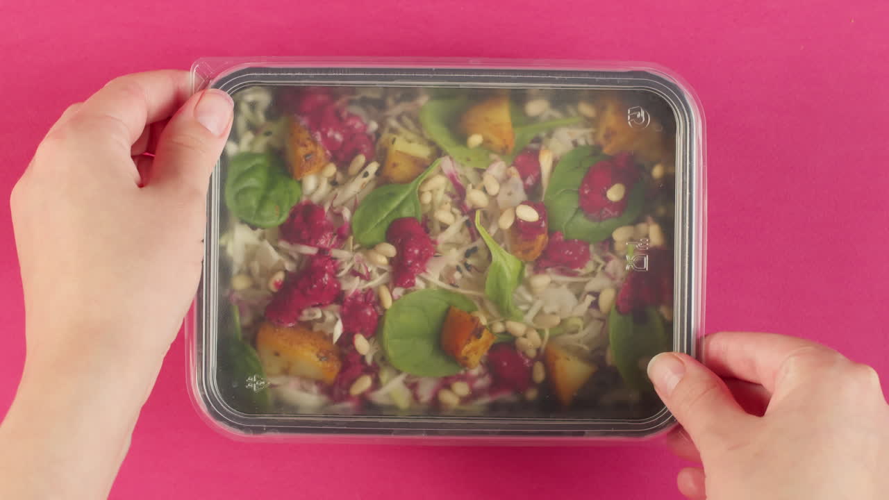Hands Closing a Healthy Salad Meal Prep Container