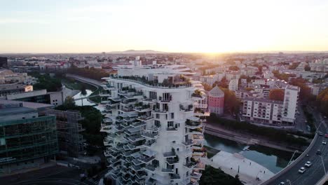 toma aérea giratoria alrededor de un edificio de apartamentos blanco durante la puesta de sol en francia