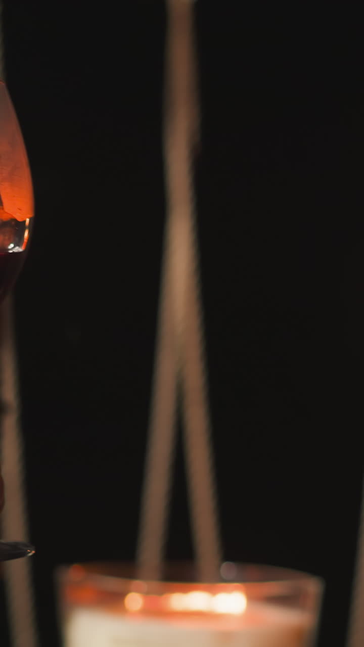 Couple drinks wine clinking glasses at romantic dinner closeup. Romantic candlelit dinner for newlyweds on glamping terrace among nature. Anniversary celebration