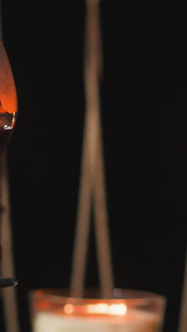 couple drinks wine clinking glasses at romantic dinner closeup. romantic candlelit dinner for newlyweds on glamping terrace among nature. anniversary celebration