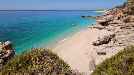 secret quiet beach hidden by rocks on mediterranean coastline of albania, white sand washed by crystal emerald water