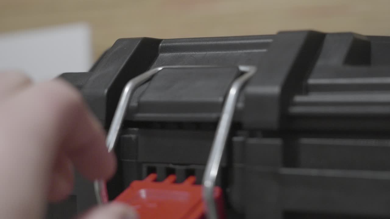 A man placing the metal latch bar of a hinge onto the lock
