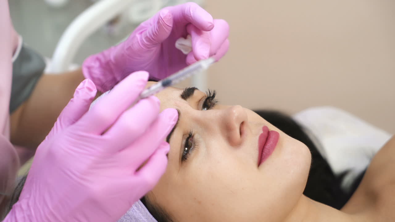 The doctor cosmetologist makes the Botulinum Toxin injection. Procedure for tightening and smoothing wrinkles. Rejuvenating facial injections.