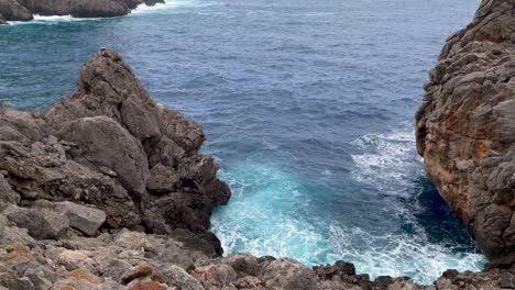 Waves-Hits-Rocks-At-Sa-Calobra-Mallorca,-Spain,-Tilt-Up