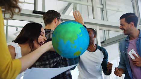 Animation-of-rotating-globe-over-happy-diverse-colleagues-celebrating-at-casual-office-meeting