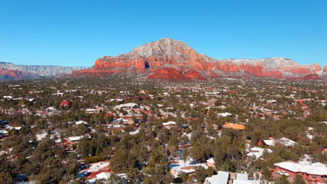 the high desert town of sedona, arizona after a light snow - descending aerial view