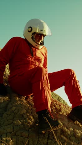 astronauta sentado en una roca pensando en el futuro de su planeta tierra