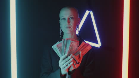 Confident Woman Holding Money Under Neon Light