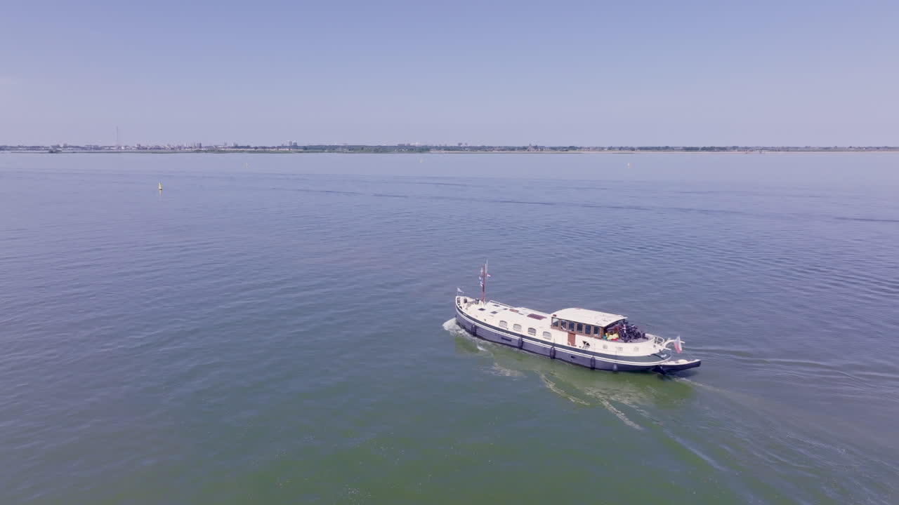 The timeless charm of a Dutch Luxemotor barge sailing through the still waters of Flevoland