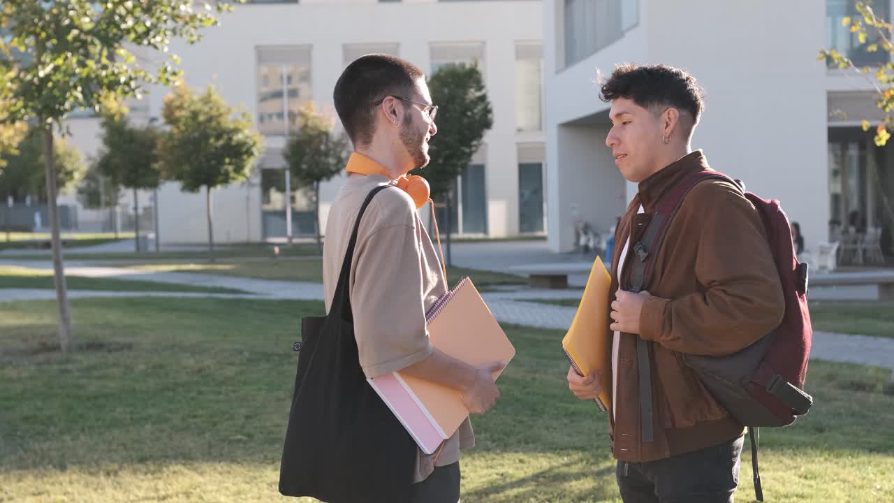 Two students talking relaxed while standing in the campus