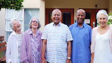 Happy-senior-friends-standing-together-in-lawn-4k