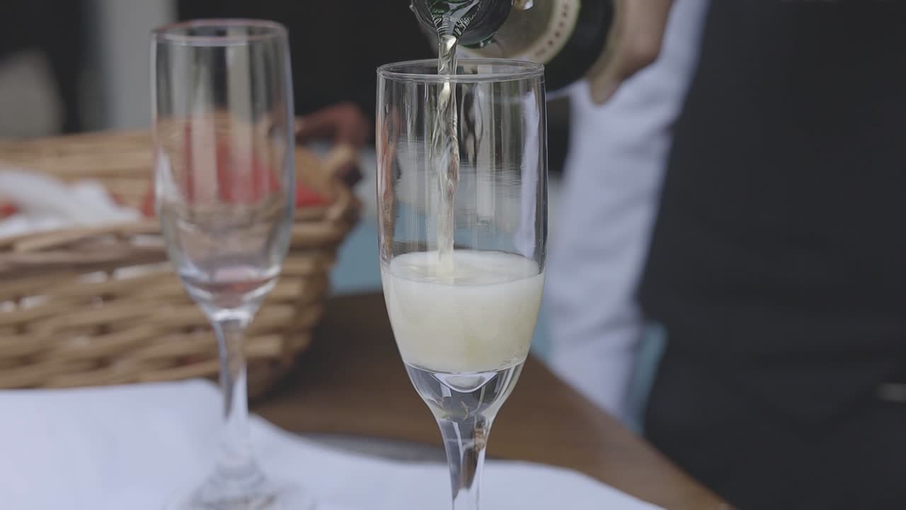 Primo piano di un flûte di champagne riempito con una bevanda frizzante